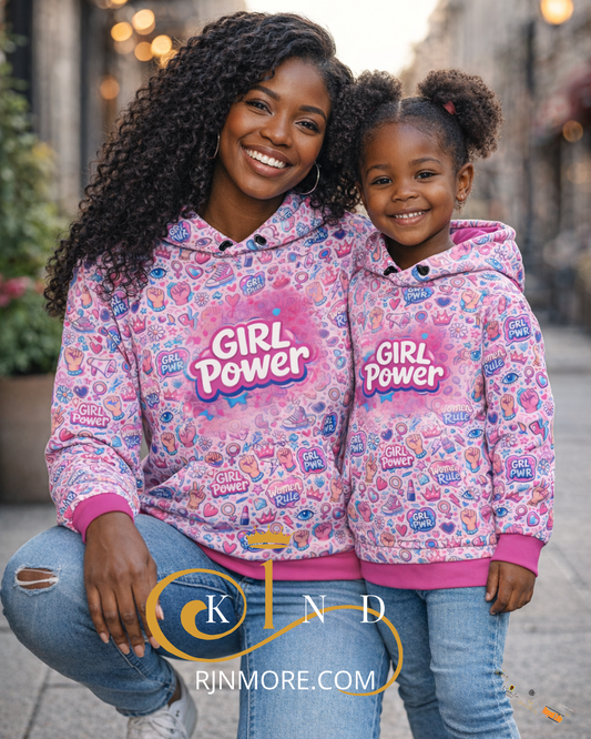 Woman and child wearing matching 'Girl Power' hoodies on a street.